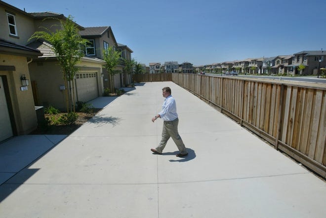 Mike Kooken makes his way toward the sideyard of a home model in a Natomas, Calif., development.