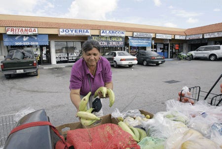 Josefa Ortega, 49, places bananas in the back of her pickup from where she sells fruits and vegetables in the "Little Managua" area of Sweetwater on Monday