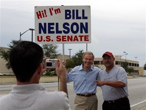 Sen. Bill Nelson, center, D-Fla., has his photo made with supporter Rico Piccard right, by Nelson's press secretary, Bryan Gulley, left, while campaigning in Orlando, Fla., Tuesday, Nov. 7, 2006. Nelson is seeking reelection against Republican challenger Katherine Harris.