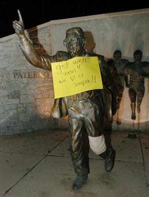A sign and wrapped left knee on the statue of Penn State head football coach Joe Paterno, is seen Sunday, Nov. 5, 2006, in State College Pa. The 79-year-old Penn State coach broke his left leg and damaged a knee ligament when two players ran into him during the Nittany Lions' loss to Wisconsin, and team officials said Sunday that surgery was being considered.