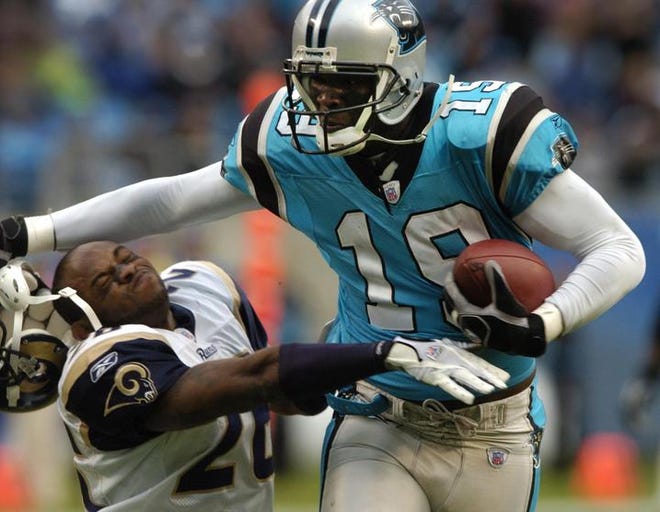 Carolina Panthers' Keyshawn Johnson (19) knocks the helmet off St. Louis Rams' Tye Hill (26) during the fourth quarter of the Panthers' 15-0 win in an NFL football game in Charlotte, N.C., Sunday, Nov. 19, 2006. Johnson was called for a face mask penalty on the play.
