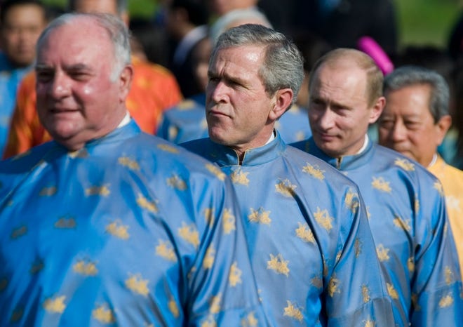 Wearing traditional "ao dai," President Bush, center, and Russia President Vladimir Putin, right, look on during the Asia Pacific Economic Cooperation (APEC) summit in Hanoi, Vietnam, on Sunday.