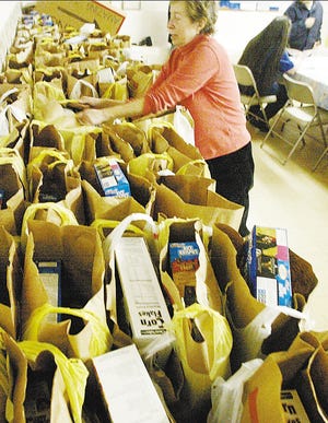 Volunteer Peggy Friedman hands out food packages to the needy on Friday at the food pantry inside St. Andrew's Episcopalian Mission in South Fallsburg. The small food pantry feeds about 200 people a month.
