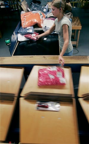 Alaina Barrett tosses items onto a conveyor to fill orders at L.L. Bean's distribution center in Freeport, Maine.