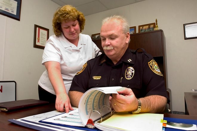 Ocala police Capt. Keith Escaravage, right, and administrative specialist Jennifer Bryan look through an organizational diary of the Ocala Retail Federation and retail theft offenders at the Ocala Police Department's West State Road 40 substation on Wednesday.