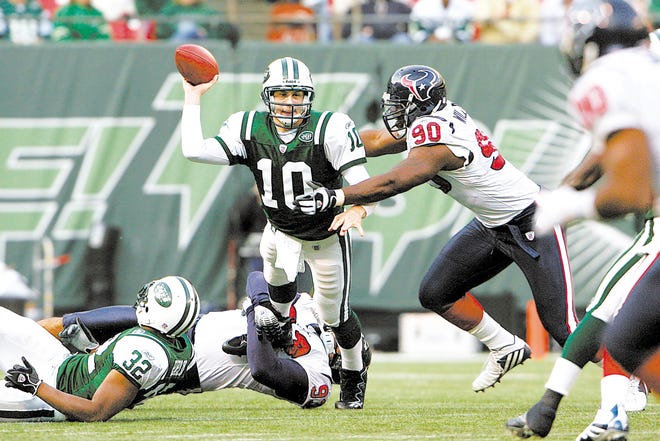 Chad Pennington , left, gets pressured by Texans’ Mario Williams. The Jets’ quarterback lost his breath on the tackle, and the crowd in the Meadowlands followed suit.
