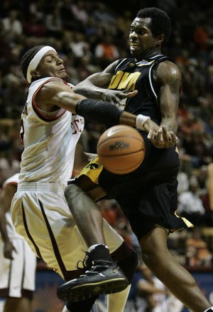 Iowa's Tyler Smith (right) draws a foul from Virginia Tech's Deron Washington during the Hokies' 69-65 victory over the Hawkeyes in an ACC-Big Ten Challenge game Wednesday.