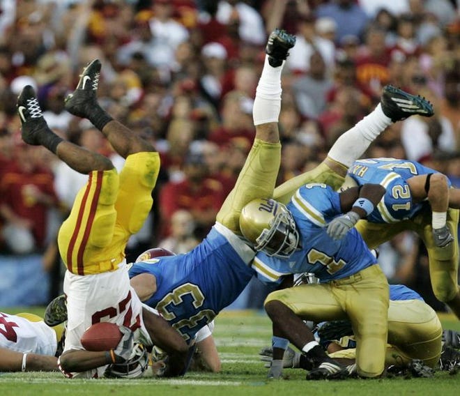 Southern Cal's C. J. Cable, left, gets upended by UCLA's linebacker Christian Taylor (33) and cornerback Alterraun Verner (1) during the third quarter of their NCAA football game in Pasadena, Calif., Saturday, Dec. 2, 2006. UCLA won 13-9. (AP Photo/Chris Carlson)