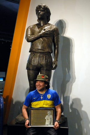 La leyenda del futbol argentino, Diego Maradona, al lado de la estatua de bronce y cemento de 3 metros de altura que fue presentada en su honor en el museo del equipo Boca Juniors en Buenos Aires, el 26 de Noviembre de 2006. La estatua fue donada por un grupo de fanaticos de Maradona.