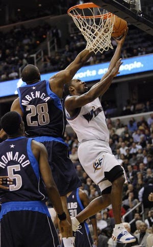 Washington's Gilbert Arenas (right) scores two of his game-high 38 points, as the Mavericks' win streak ended.