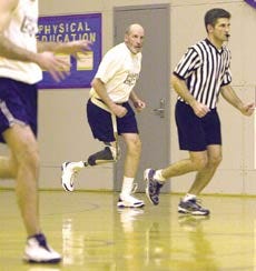 Dave Emery changes direction and runs in step with referee Guy Mitchell in a basketball game in 2003.