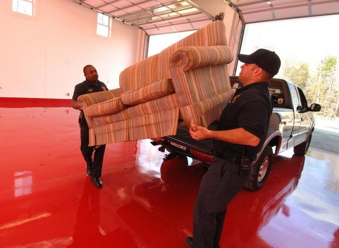 Fire Lt. Dale Partlow (left) and firefighter Dwayne Sanford move furniture into their new fire station on Sugarcreek Drive.