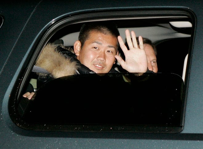Daisuke Matsuzaka waves to the media after arriving at Hanscom Airport in Bedford, Mass., on Wednesday.