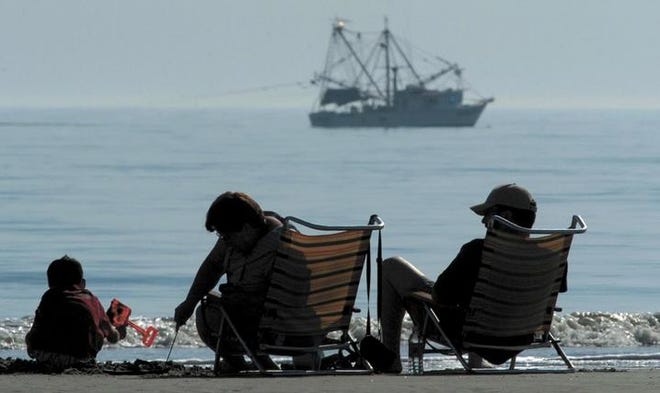 Beachgoers enjoy the unseasonably warm weather and the view at Hilton Head Island, S.C.