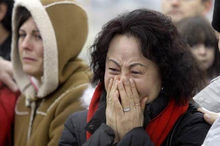 Maria Kim, the mother of Jerry Cooke, cries out during a news conference at the Hood River Airport Monday, Dec. 18, 2006, in Hood River, Ore. A missing climber found dead in a snow cave on Mount Hood was identified as a Dallas man who had placed a distress call to relatives a little more than a week ago, a person close to the family said Monday.
AP photo