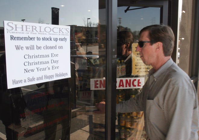 A sign reminding customers of the upcoming holidays in Georgia greets customers, including Kent Brooks of Alpharetta, Ga., at Sherlocks Beer and Wine Warehouse in Marietta, Ga., Friday, Dec. 15, 2006. Georgia is one of the states that completely bans the Sunday sale of any alcohol for off-premises consumption. Both Christmas and New Years eve are on Sunday this year. (AP Photo/Gene Blythe)