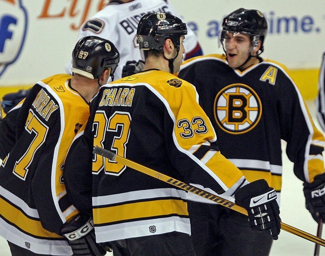Patrice Bergeron (right) celebrates with Glen Murray and Zdeno Chara (center) after Murray scored in the first period against Vancouver.