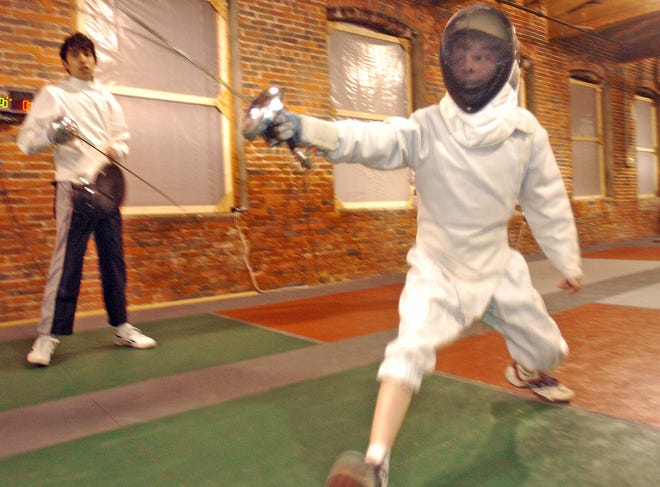 North Andover student Owen Huzar lunges forward, or advances, in a bout during a Tuesday night practice at Penta Fencing Club in Lawrence.