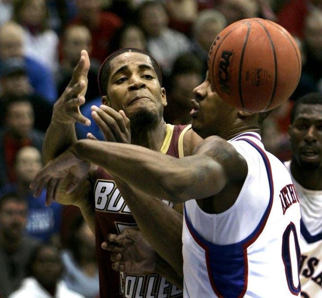 Boston College forward Sean Williams (left) passes the ball under pressure from Kansas' Darrell Arthur during the second half. Williams, the NCAA leader in blocked shots, blocked seven, scored 19 points and grabbed 15 rebounds, but it wasn't enough for the Eagles.