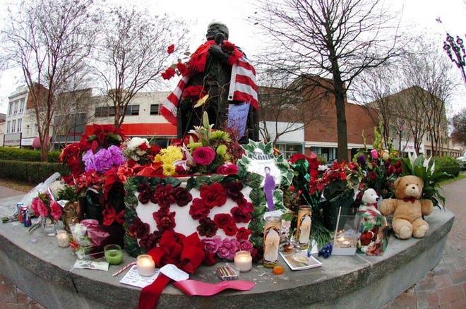 Flowers and candles cover the base of the James Brown statue on Broad Street in downtown Augusta a day after his death.