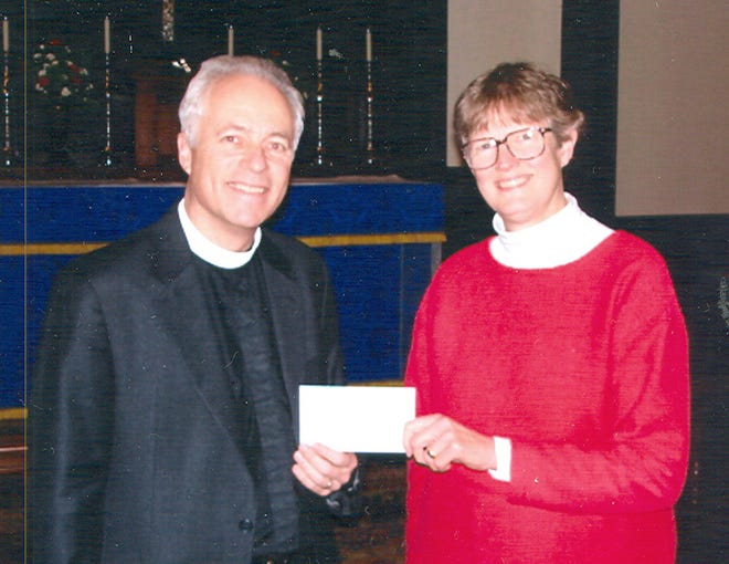 Checks in excess of $500 are presented to Janet Fitch Parker, left, of the Food Pantry by the Rev. Andrew Stoessel, rector of St. Michael's Church and president of the Ministerial Association.