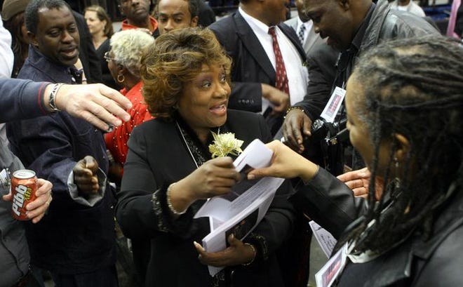 City employee Geri Sams is surrounded as she hands out programs during the public memorial service. Fans danced and sang along with performers throughout the service, which featured Mr. Brown's music sung by friends.