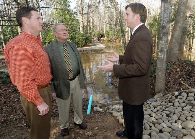 Joe Mullinax, executive director of Hatcher Garden and Woodland

Preserve, right, describes the process for the storm water recycling

project in the gardens to State Sen. John Hawkins, left, and Myles

Whitlock, chairman of the board of Hatcher Gardens.