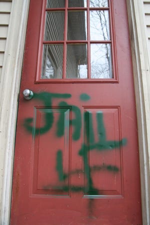 A Franklin man stands accused of painting a swastika and the word "Jail" on his neighbor's door on King Street in Franklin.