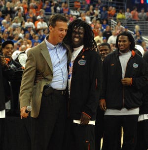 Florida coach Urban Meyer hugs All-America safety Reggie Nelson during an appearance at the Gators' basketball game against Arkansas at the O'Connell Center in Gainesville on Tuesday night.
