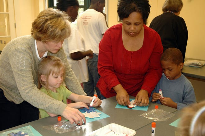 Samantha Douberly, daughter Anna Grace, 4, Janice Harris and son Juston, 6, work on creating a snow-themed make and take project during the Double Fun event at the Bull Street library.