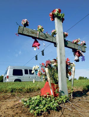 Traffic passes a roadside memorial along U.S. 27 at Polo Park in Four corners. Stoplights were installed near there in 2005.