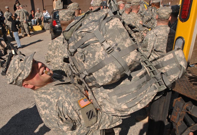Spc. Stephen La Ragione enjoys a cigar as he loads a rucksack onto a truck at Fort Stewart for transport to Hunter Army Airfield where he and the rest of the 2nd Battalion, 7th Infantry Regiment were scheduled to depart for Iraq.