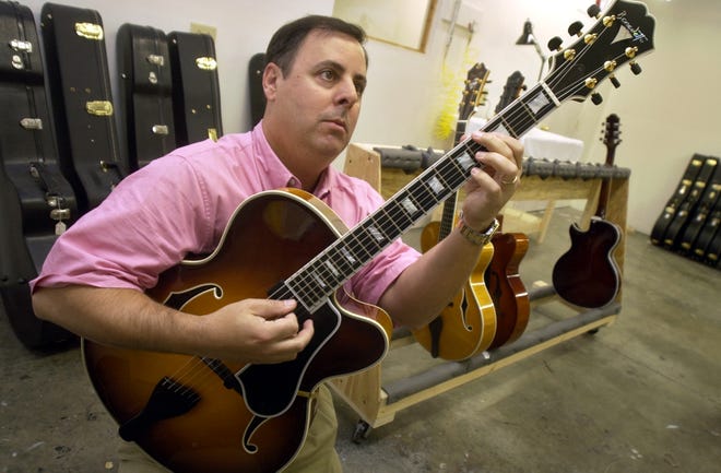 Jazz guitarist Howard Paul, president and CEO of Benedetto Guitars Inc., demonstrates a few notes on one of the company's instruments.