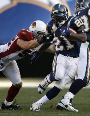 Chargers running back LaDainian Tomlinson drags would-be tacklers against the Cardinals.
