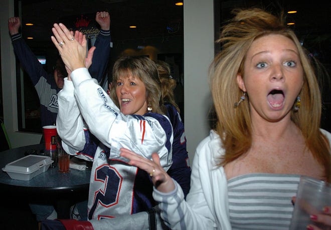 In the foreground, Nicole Thomas, of Norfolk, reacts as she watches the Patriots game at Doc's Sports Bar & Grille in Milford yesterday. In the back, Laurie Smith, also of Norfolk, cheers on the team.
