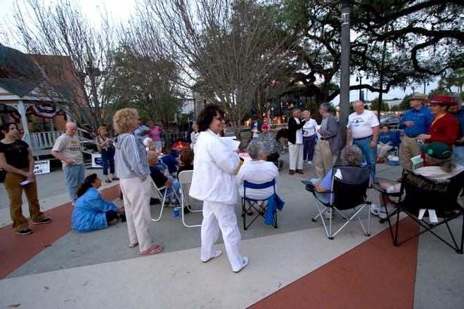 Delphine Herbert, center, founder of Marions For Peace, and others gather on the downtown Ocala square to discuss U.S. involvement in the Iraq war on March 19, 2006.