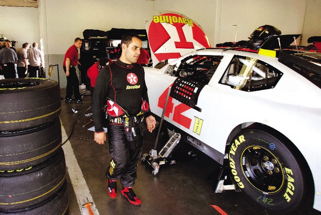 Juan Pablo Montoya checks on his car while crew members make adjustments in the garages at Daytona International Speedway during NASCAR auto racing testing in Daytona Beach, Fla., Tuesday.