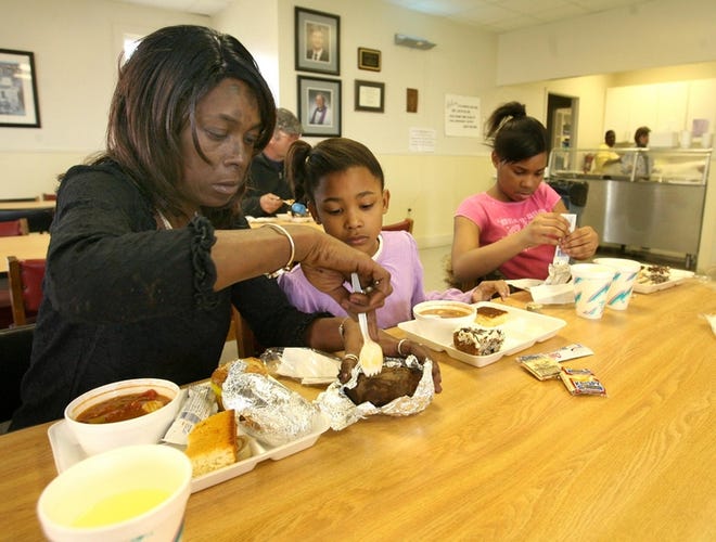 From left, Debra Mills eats with her daughters, Alana Mills, 7, and Joslyn Mills at the Community Soup Bowl on Friday. Debra Mills is on disability and does not work.
