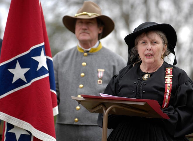 Elizabeth Piechocinski, president of the local chapter of United Daughters of the Confederacy, delivers opening remarks during a ceremony Sunday at Laurel Grove Cemetery restoring the grave marker of Confederate soldier Maj. Joseph L. Locke, who died in 1864. Joe Dawson of the Sons of Confederate Veterans acted as Confederate flag bearer.