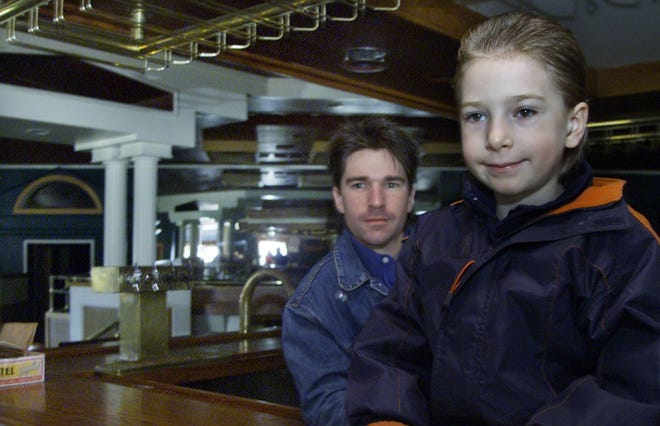 Adam Israel is pictured with his son Chase, then 6, at his Monticello bar in April 2002.