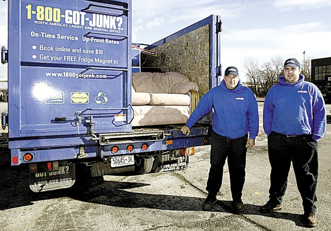 John Baccello, left, and Ryan Wonderland of 1-800-GOT-JUNK stand by a couch in the back of their truck in the Town of Wallkill yesterday. The couch was turned away by the Salvation Army.