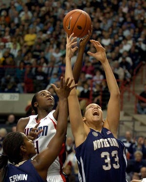 Connecticut's Tina Charles, center, takes a rebound away from Notre Dame's Melissa D'Amico, with the Irish's Crystal Erwin, left, in Saturday night's contest.