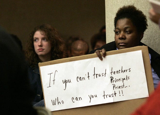 Paulette Hunter, of Allentown holds up a sign during a school board meeting in Allentown, Jan. 25. Hunter, who has an autistic son, and other parents packed the meeting to protest the way the district responded to a series of alleged sexual assaults at an Allentown elementary school.