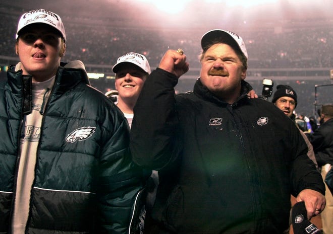 Philadelphia Eagles head coach Andy Reid, right, reacts to the crowd as he and his sons Garrett, left, and Britt, center, walk off the field after the Eagles beat the Giants on Dec. 30, 2001.