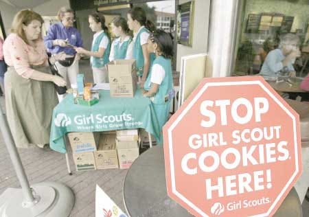 Girl Scouts from the Texas Council sell cookies, Friday, Feb. 23, 2007, in Dallas. The Girl Scouts have marked their 90th year in the cookie business by getting most of the artificial fat out of all varieties of their iconic treats, which had been under attack by a few health-focused consumer groups. (AP Photo/Matt Slocum)
			AP Photo