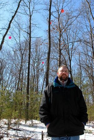 Southborough Town Engineer John Woodsmall stands on Fairview Hill, the proposed site if a 2 million-gallon water storage tank. The balloons mark the height of the proposed tower.