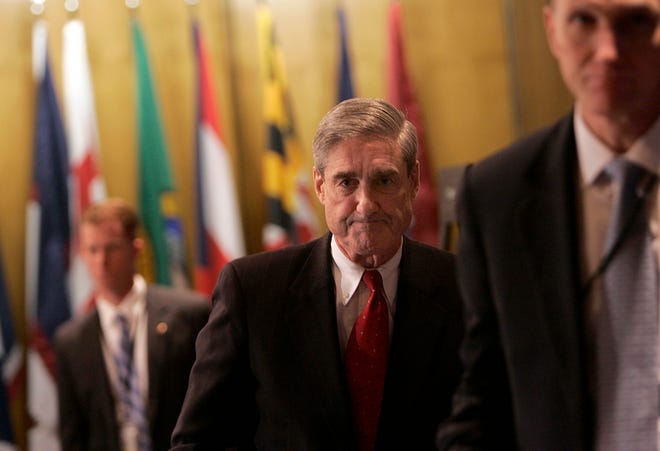 FBI Director Robert Mueller leaves a news conference at FBI headquarters in Washington on Friday, where he discussed obtaining personal information about Americans.