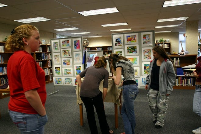 After helping with the hanging of the art exhibit, Loravie Tvaroch, Katie Newton, Dana Rutledge and Amanda Baker take time to preview the works of other art classes.