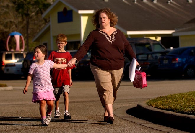 Eileen Small leads her children, Brian, 8, and Lizzy, 4, out of Michael's Learning Center at the Jewish Community Center in Sarasota on Monday.