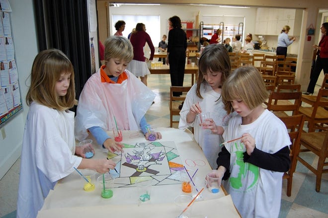 Sunday school students at Church of the Redeemer paint a stained-glass panel. From left are second-grader Brittney Butler, third-grader Tristan Rivers, second-grader Amanda Dischinger and first-grader Samantha Dischinger.